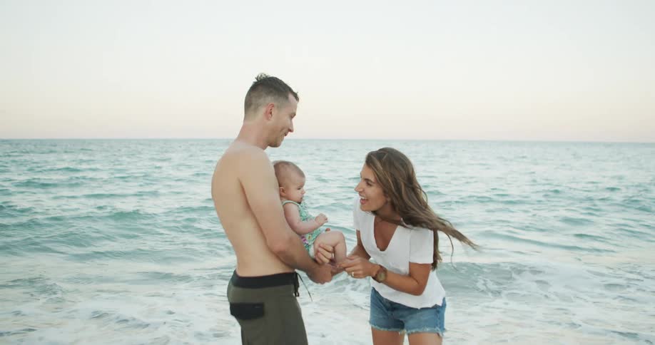 A couple and their baby at the beach