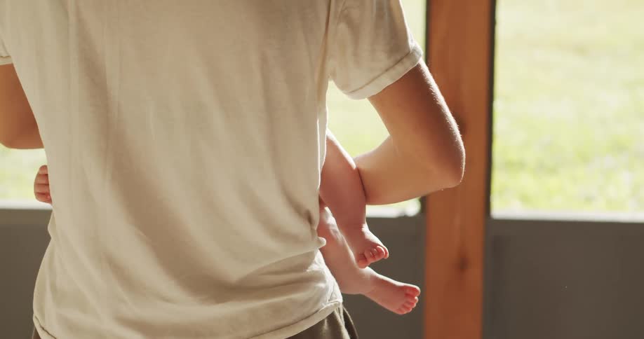 Back of a person rocking a baby to sleep
