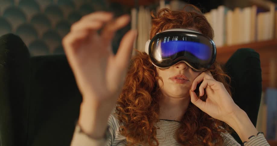 The woman waves her hand while using virtual reality
