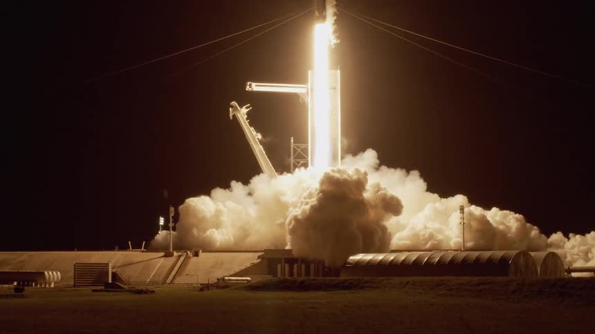 A rocket blasts off from a launch pad and releases fire and smoke