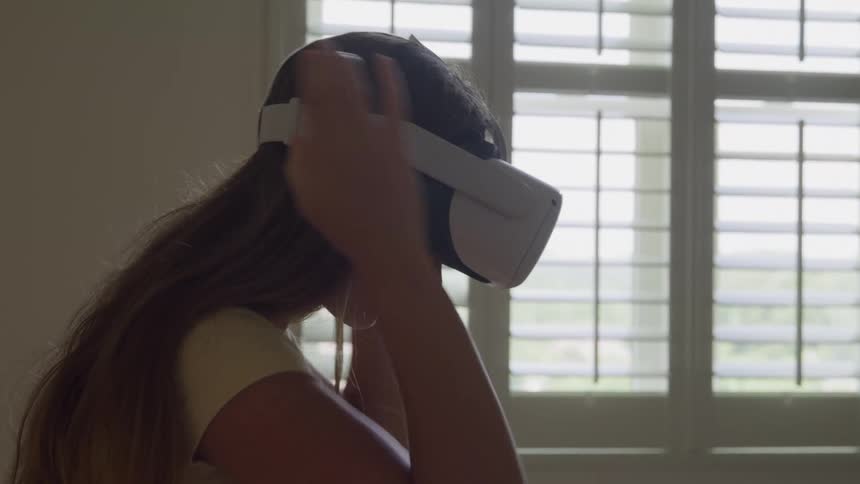Teenage girl puts on a virtual reality headset