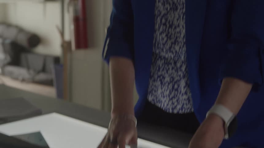 The woman looks at photos and writes on a post it note