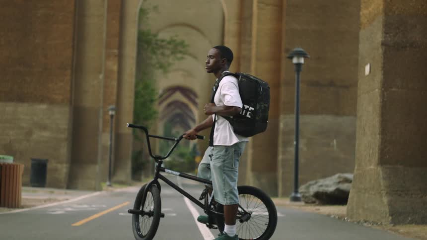 A man stands with his bike on a path