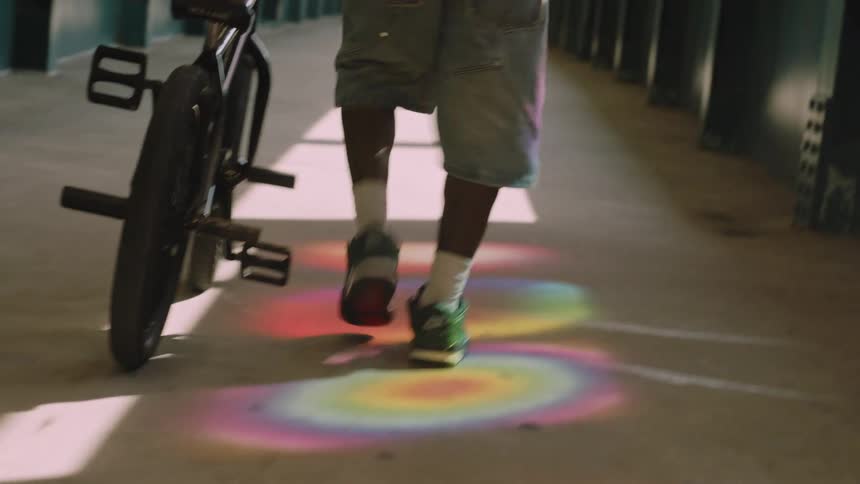 A guy walks his bike down a path