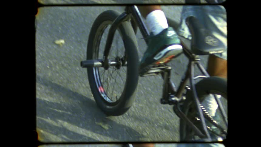 A teenage boy wearing a backpack is riding on a bike