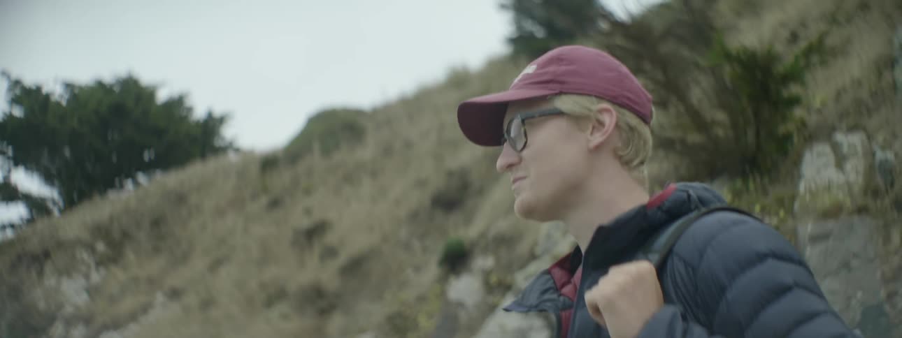 A man smiles while looking around