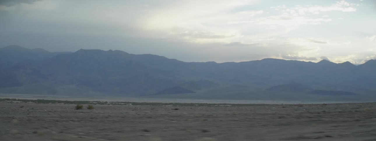 A long field is under the cloudy sky