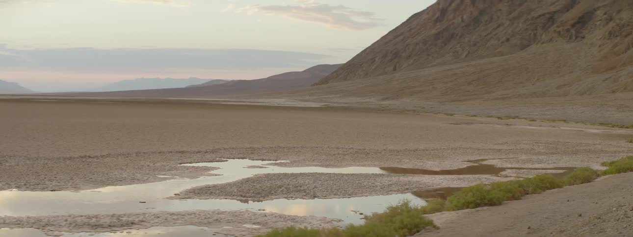Water pools at the base of hills near a shoreline