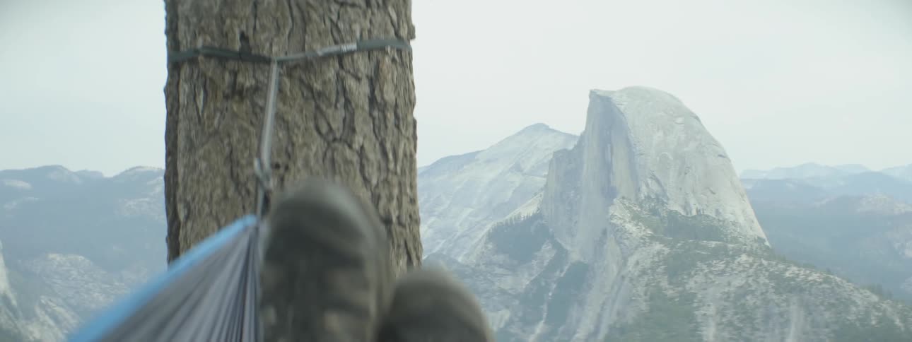 Boots of someone in a hammock overlooking some mountains