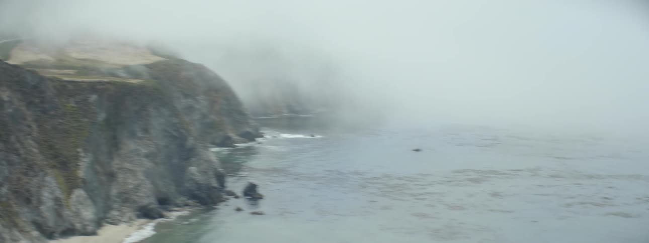 Vehicles cross a mountain bridge on the coast