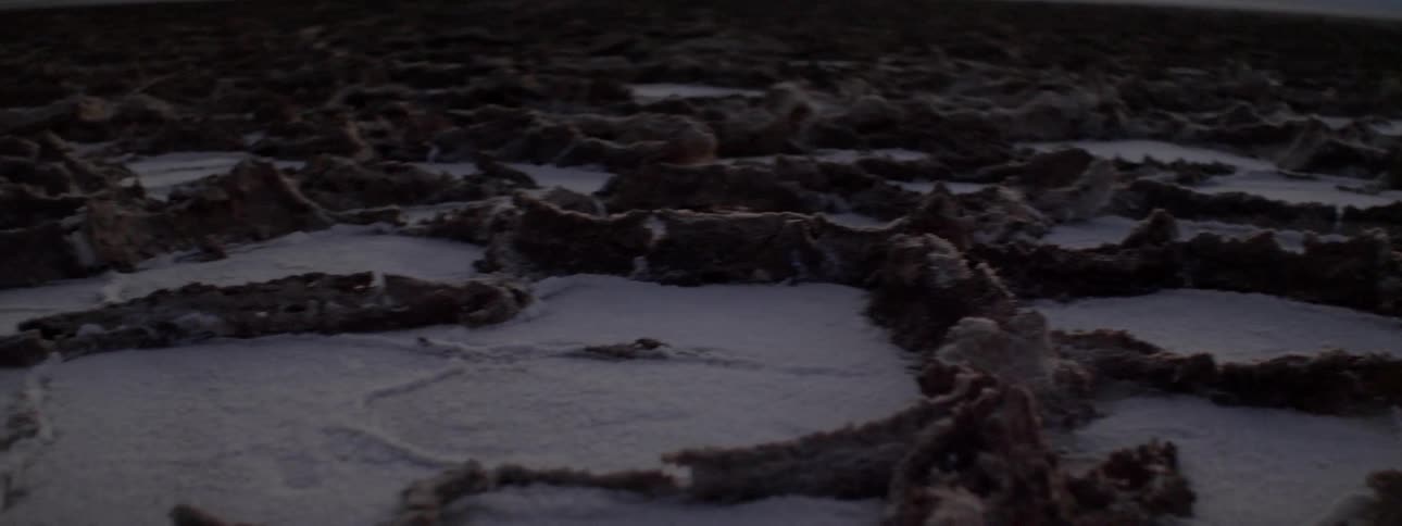Dirt and rock formations form bowls to hold the snow across a vast plain