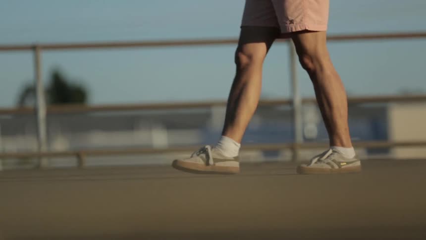 A man kicks around a soccer ball on a pier