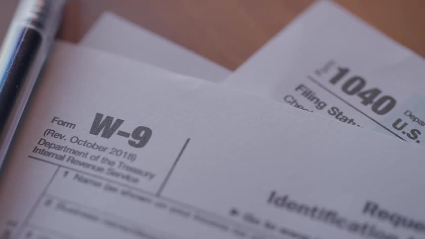 Close up of w9 and 1040 forms on a table