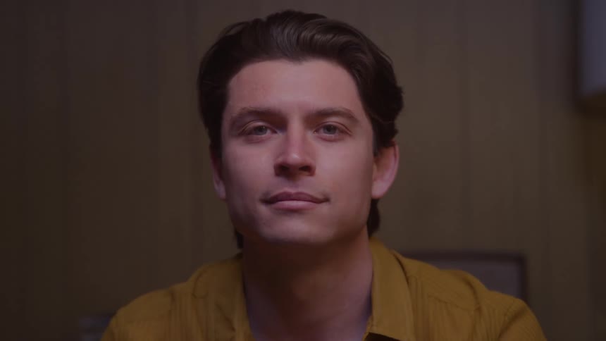 Close up portrait of a young man sitting in a room