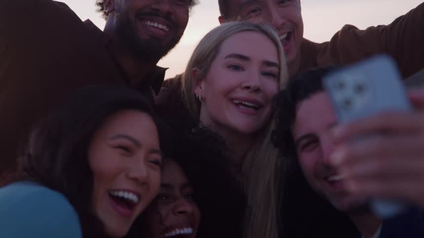Friends happy and laughing gathering for a selfie with a smart phone