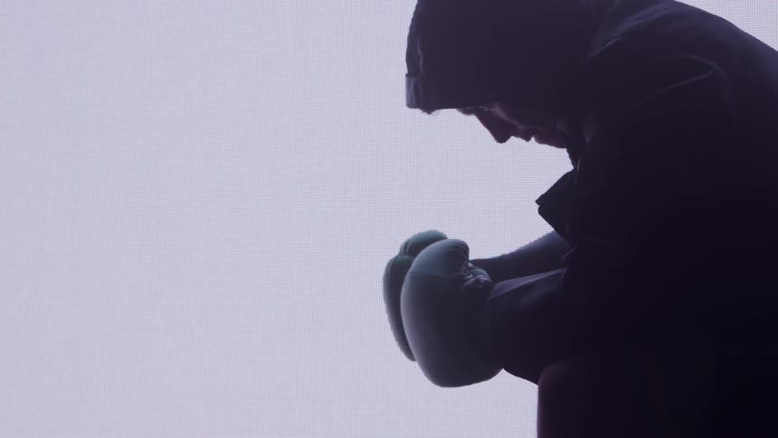 The boxer is tapping his gloves together