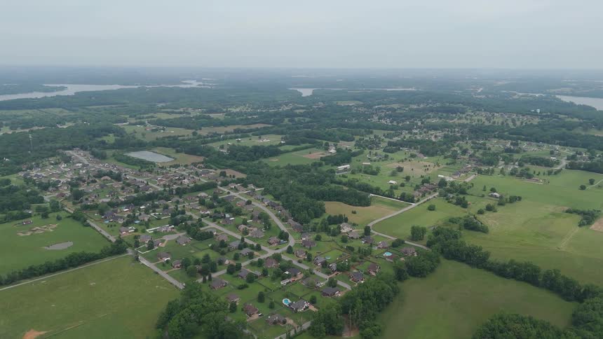 Flying over a large area with a town and fields