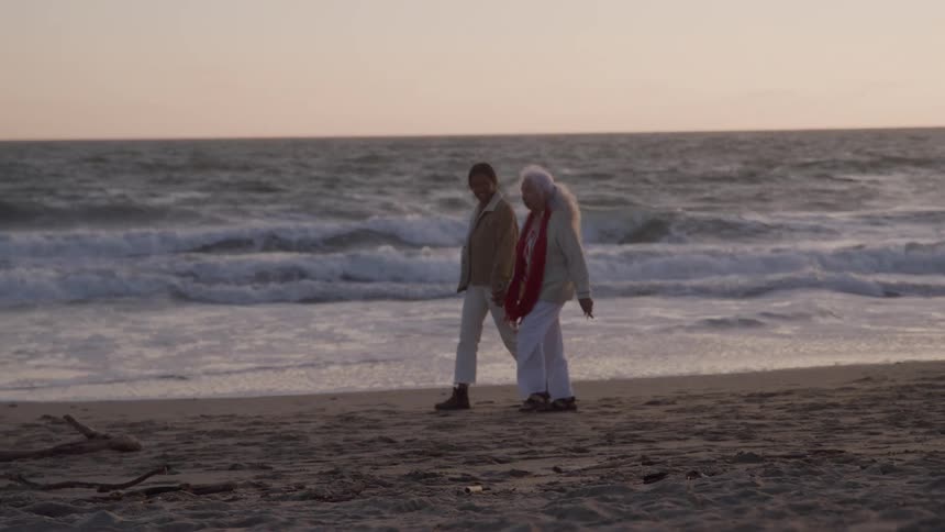 Women stroll together on the beach