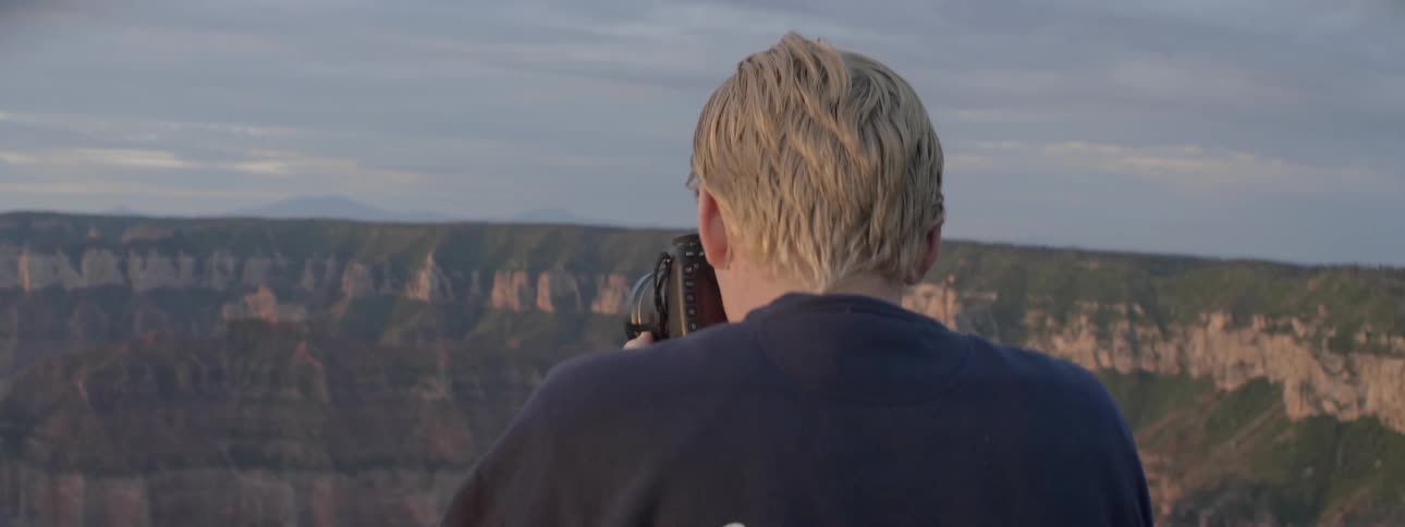 A man photographs a canyon