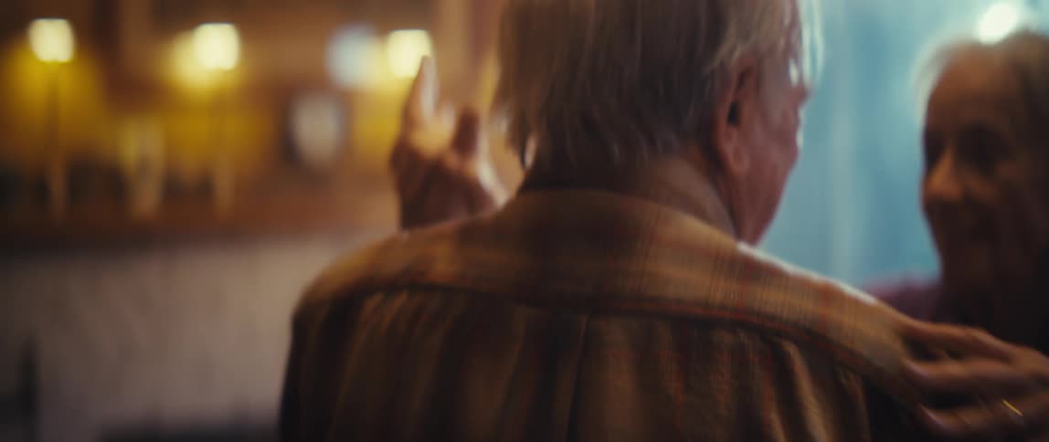 A couple dances and smile at each other