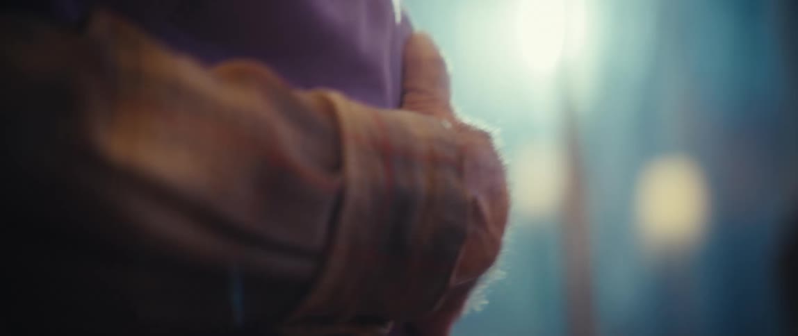 An elderly couple is dancing very closely together