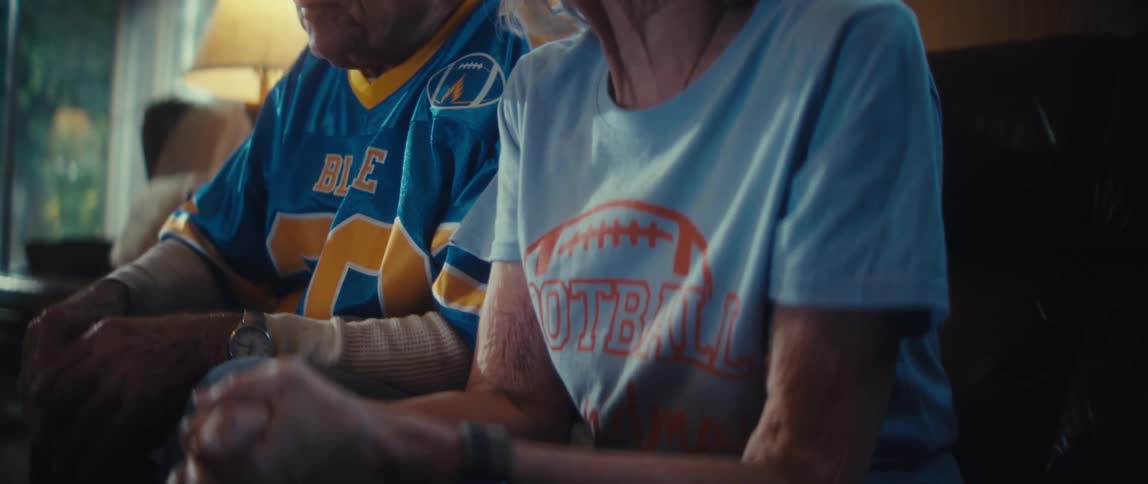 The man and woman watch a sports game together