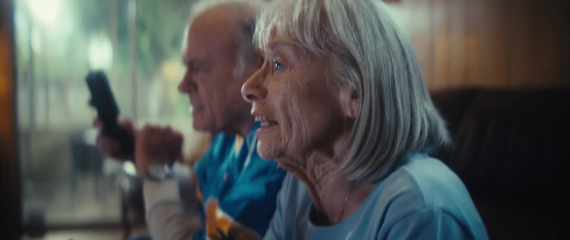 Elderly couple cheering while watching a game