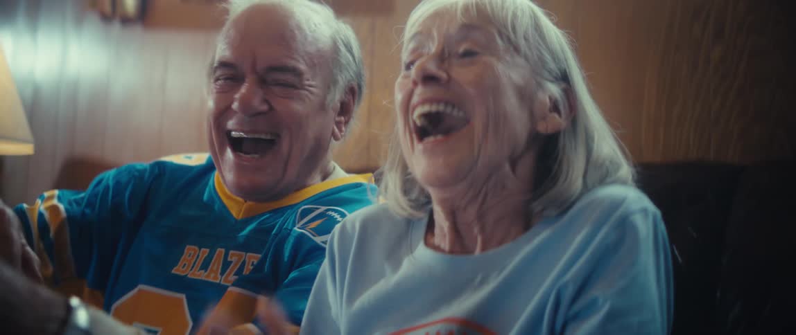 An elderly couple cheers