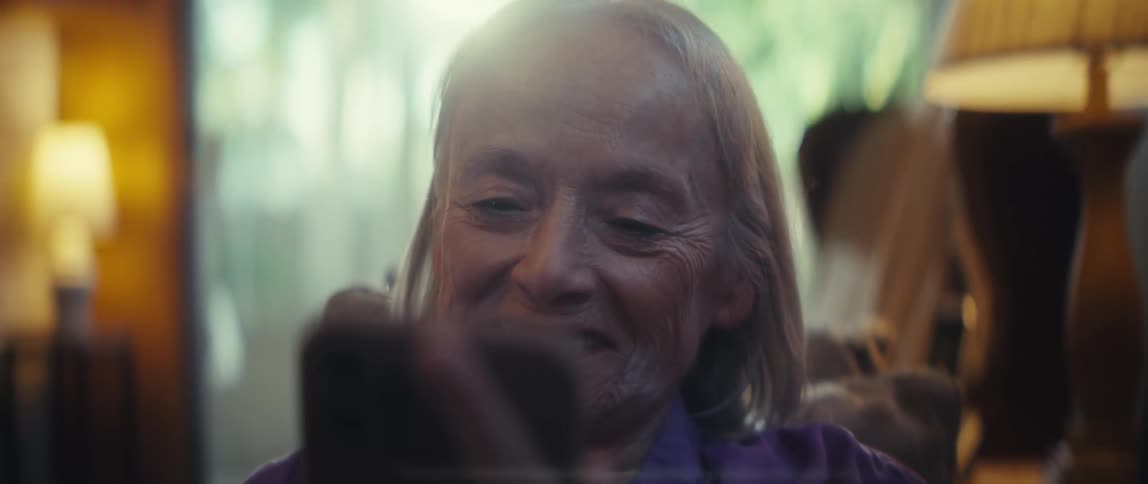 The woman smiles at her cell phone