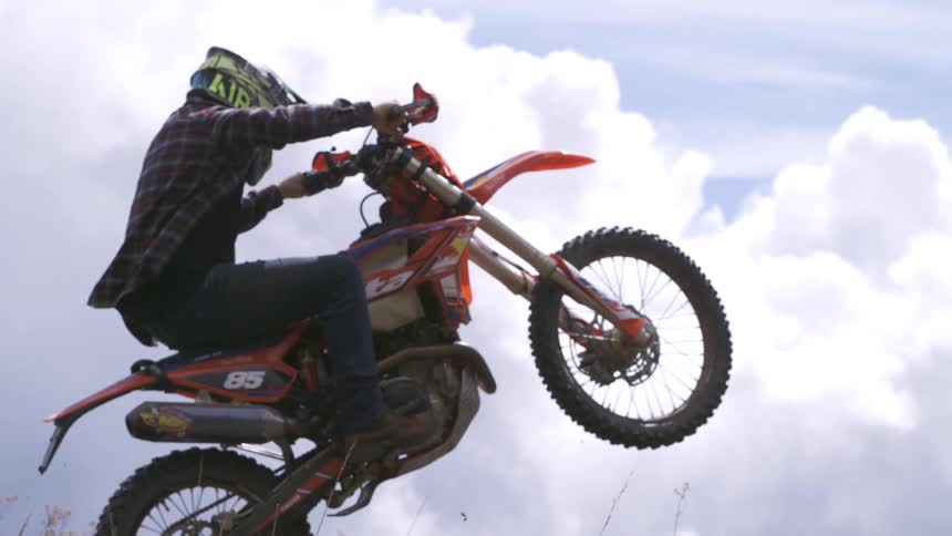 A man is jumping on a motorcycle