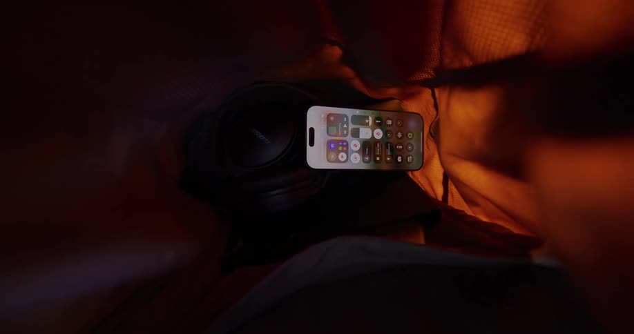 Close up of a mobile phone with other electronic gadgets in a backpack