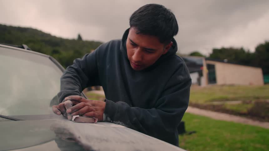 The man is doing bodywork on his car