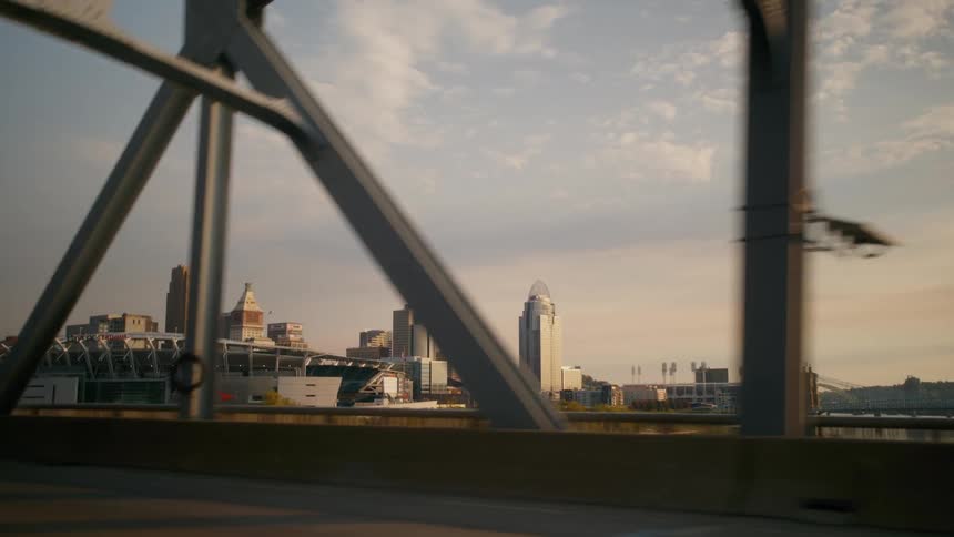 Cityscape at sunset seen through the structure of a bridge