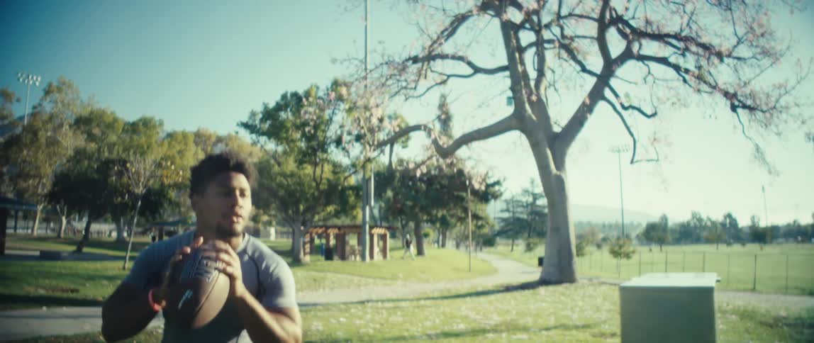 Man throws a football in a park