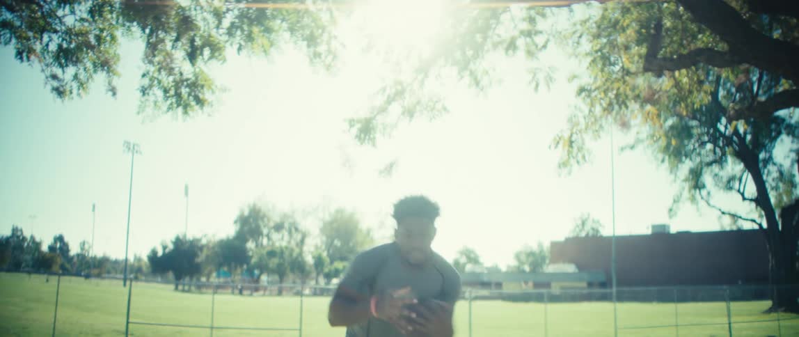 A man holding a football is doing practice drills outside