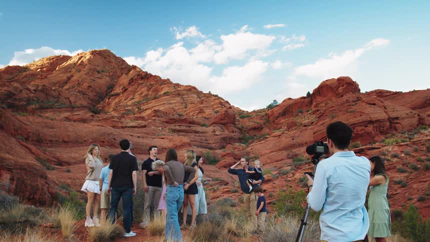 Family gathering for a family photo with a photographer in the desert