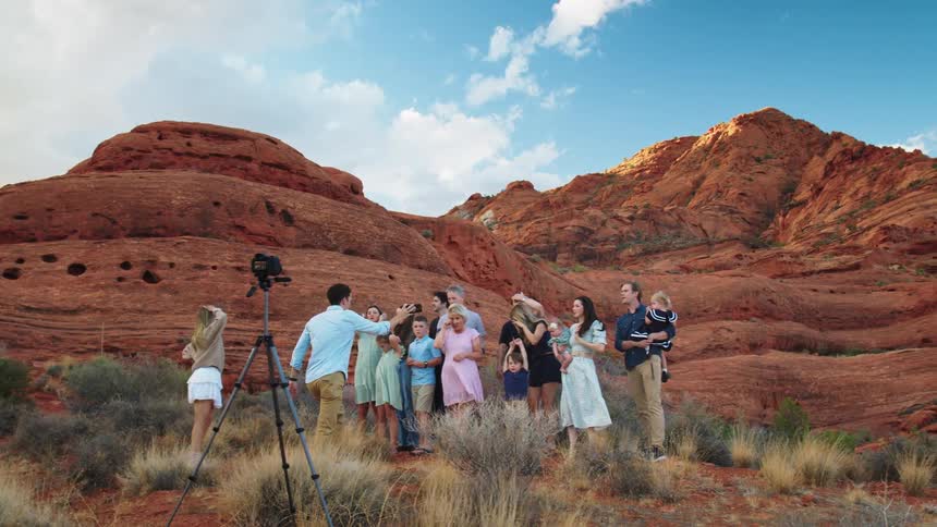 A large family poses for a picture by the mountain