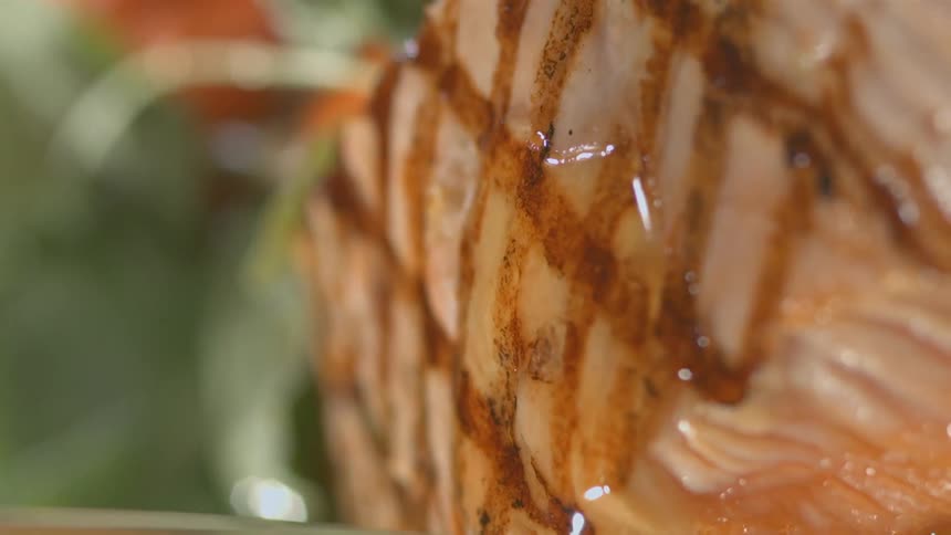 A piece of fish is covered with gravy