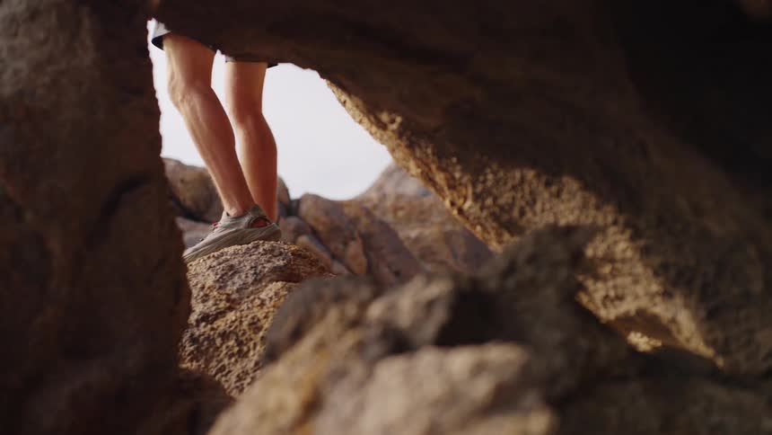 The man climbs over the rocks
