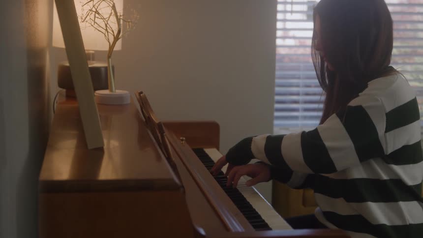 White teenager girl playing a piano indoors during day time