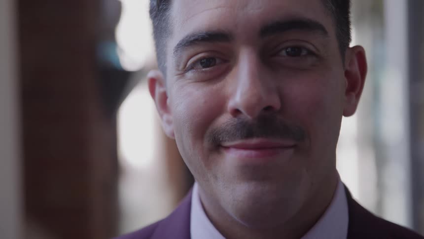 The man with a mustache smiles