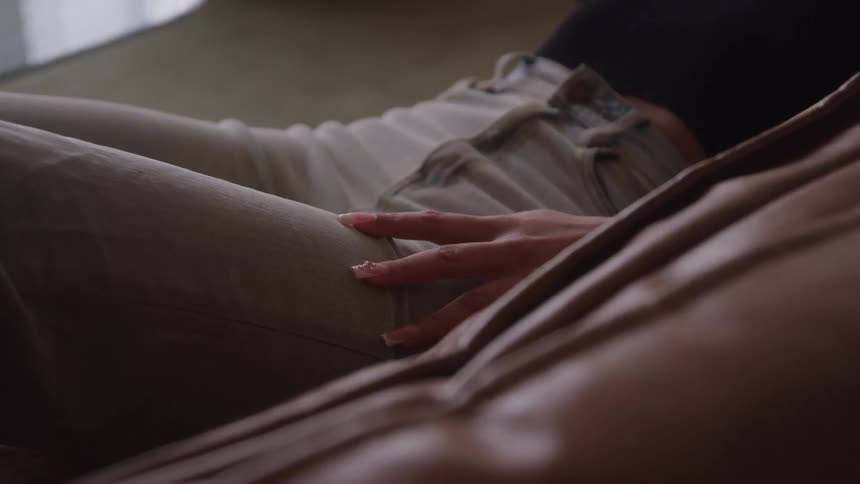 The woman is laying on the couch
