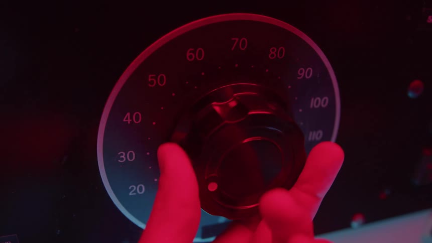 Hand adjusts a safe dial under red light