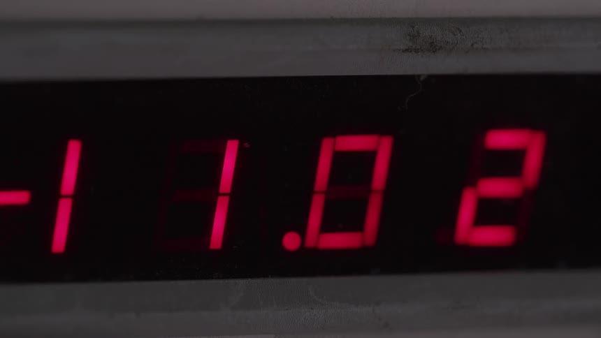 A close view of a digital electronic display shows red glowing numbers rapidly changing
