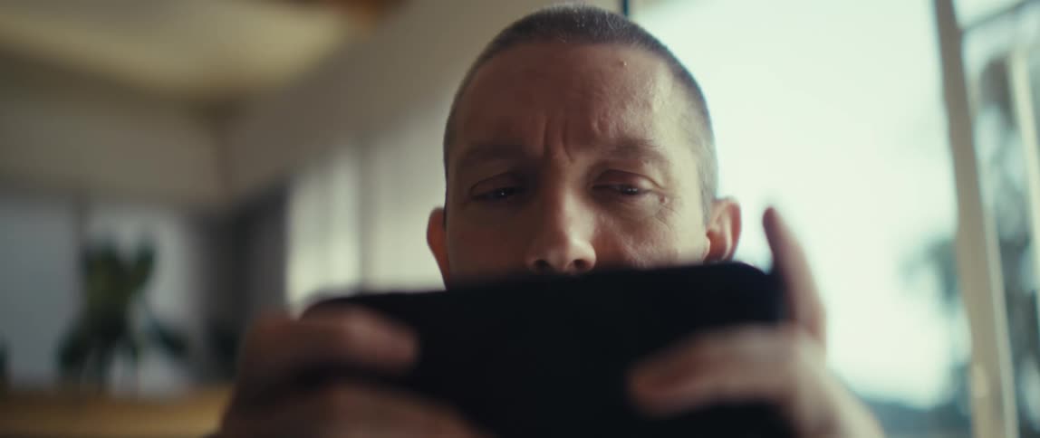 The man is concentrating on his cell phone