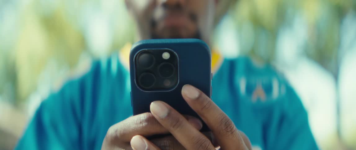 The man uses his blue cell phone outside