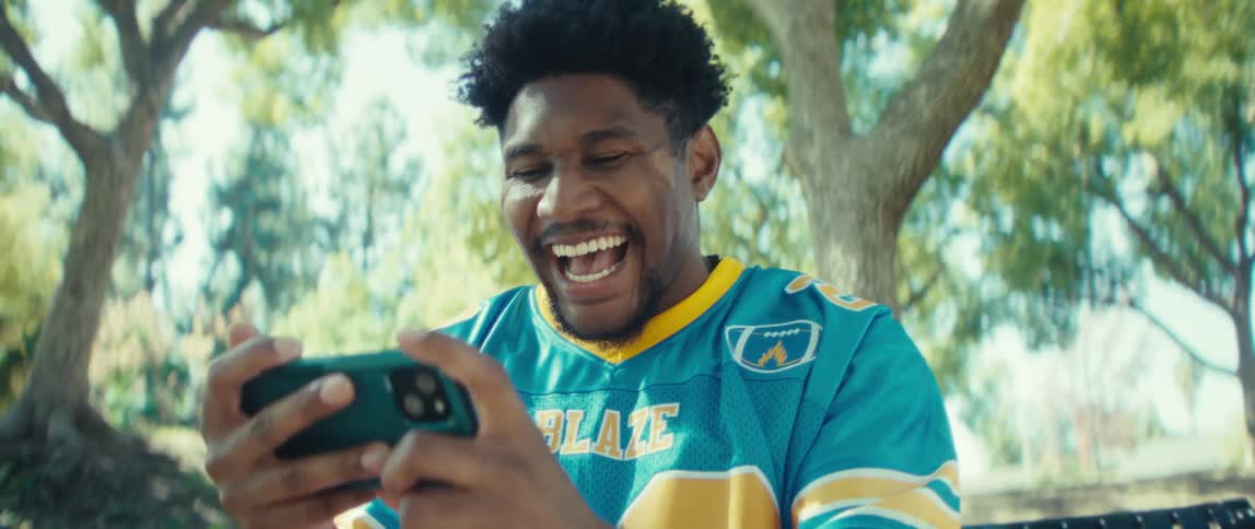 The man laughs while using his cell phone