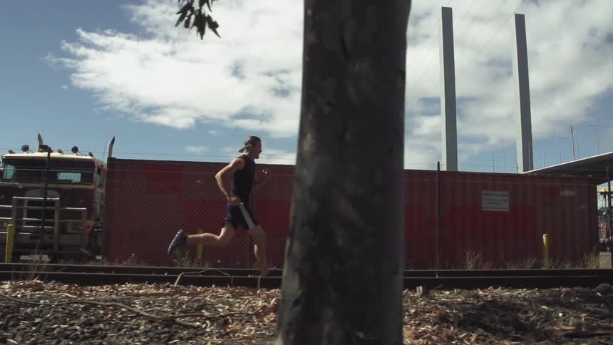 Man running along railroad tracks