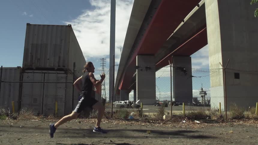 Man running next to a fence outside