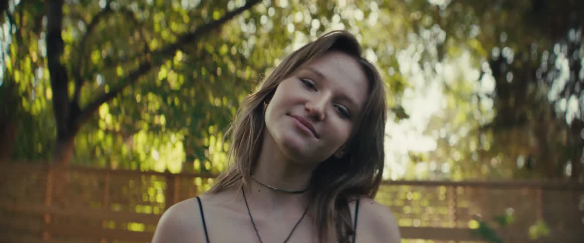 The girl smiles in her yard